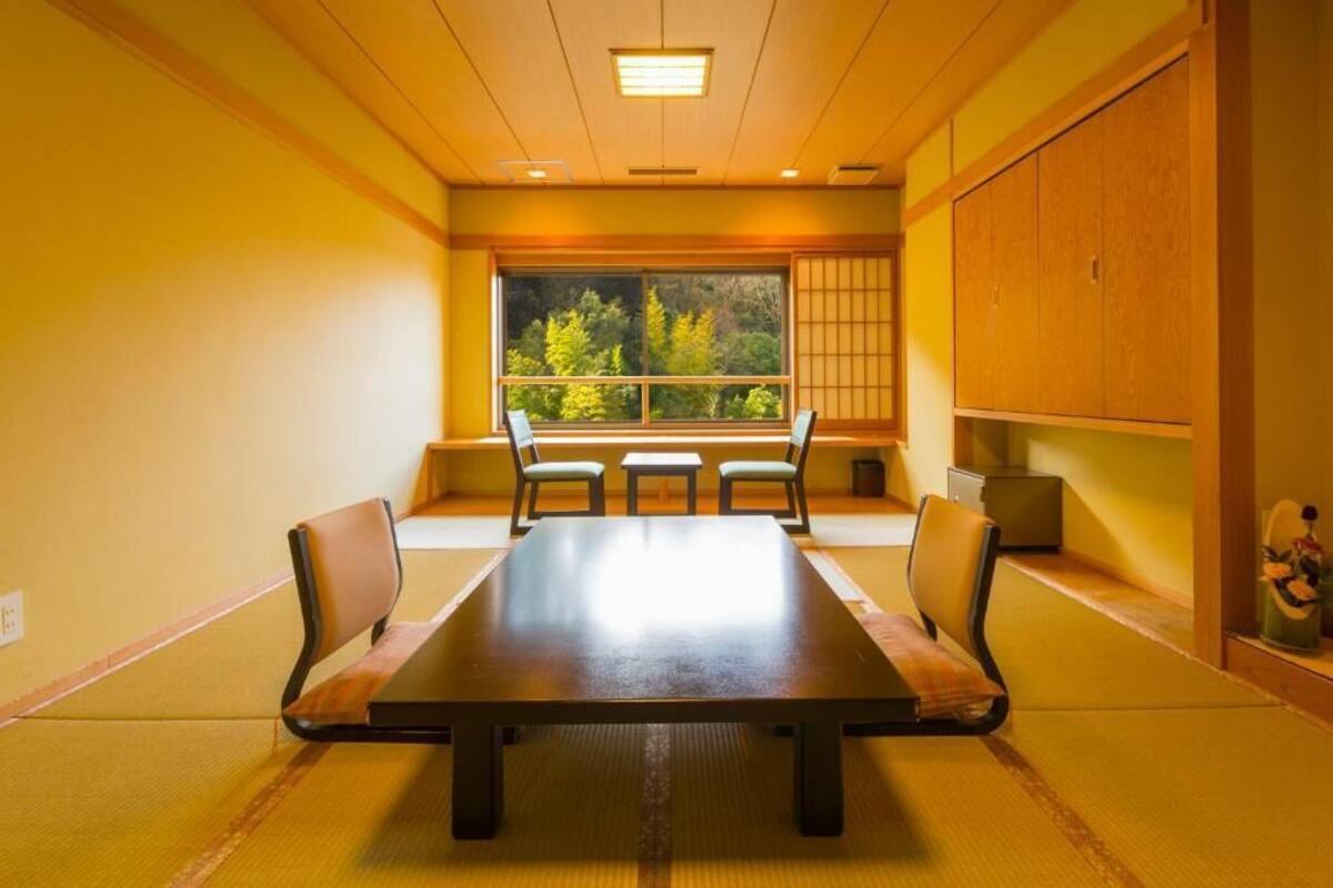 Een traditionele Japanse kamer met tatami vloerbedekking, een lage tafel en shoji schermen.