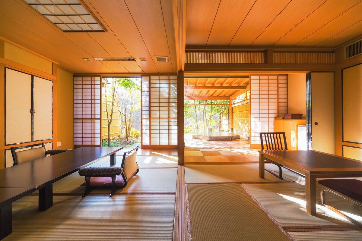 Een traditionele Japanse kamer met tatami vloeren, schuifdeuren en een lage tafel met zitplaatsen.
