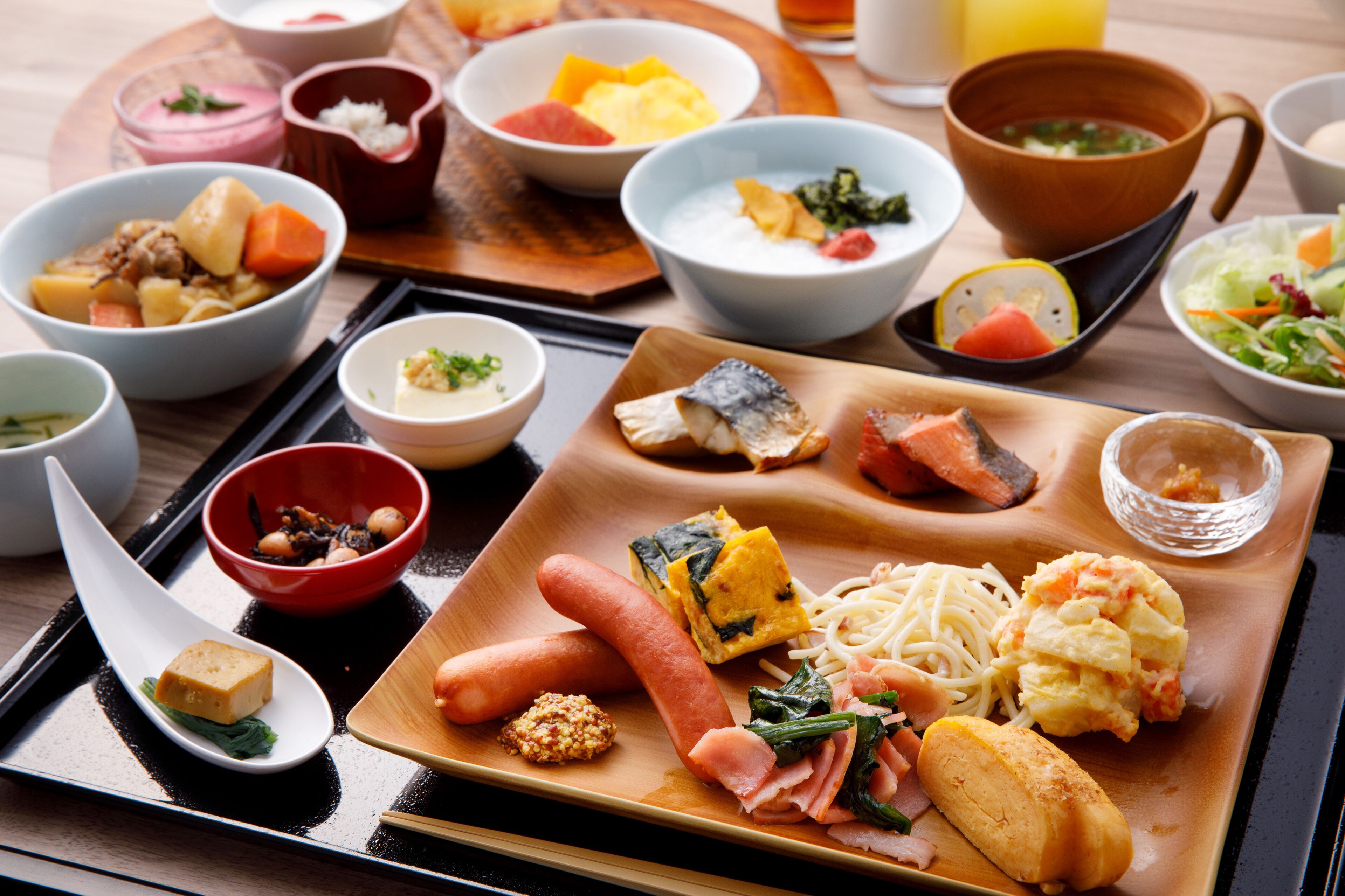 A variety of dishes on a wooden tray, including seafood, vegetables, and tofu.