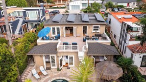 A modern two-story house with a swimming pool, solar panels, and a patio with lounge chairs. - Wavebreak by Avantstay Close to Beaches/surfing (Solana Beach)