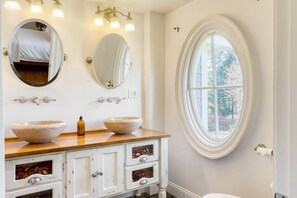 A bathroom with two large oval mirrors, a wooden vanity, and a large window. - Rockspring by Avantstay Huge Berkshires Estate (Stockbridge)