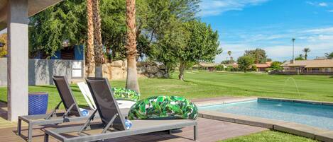 A poolside area with lounge chairs and a small pool.