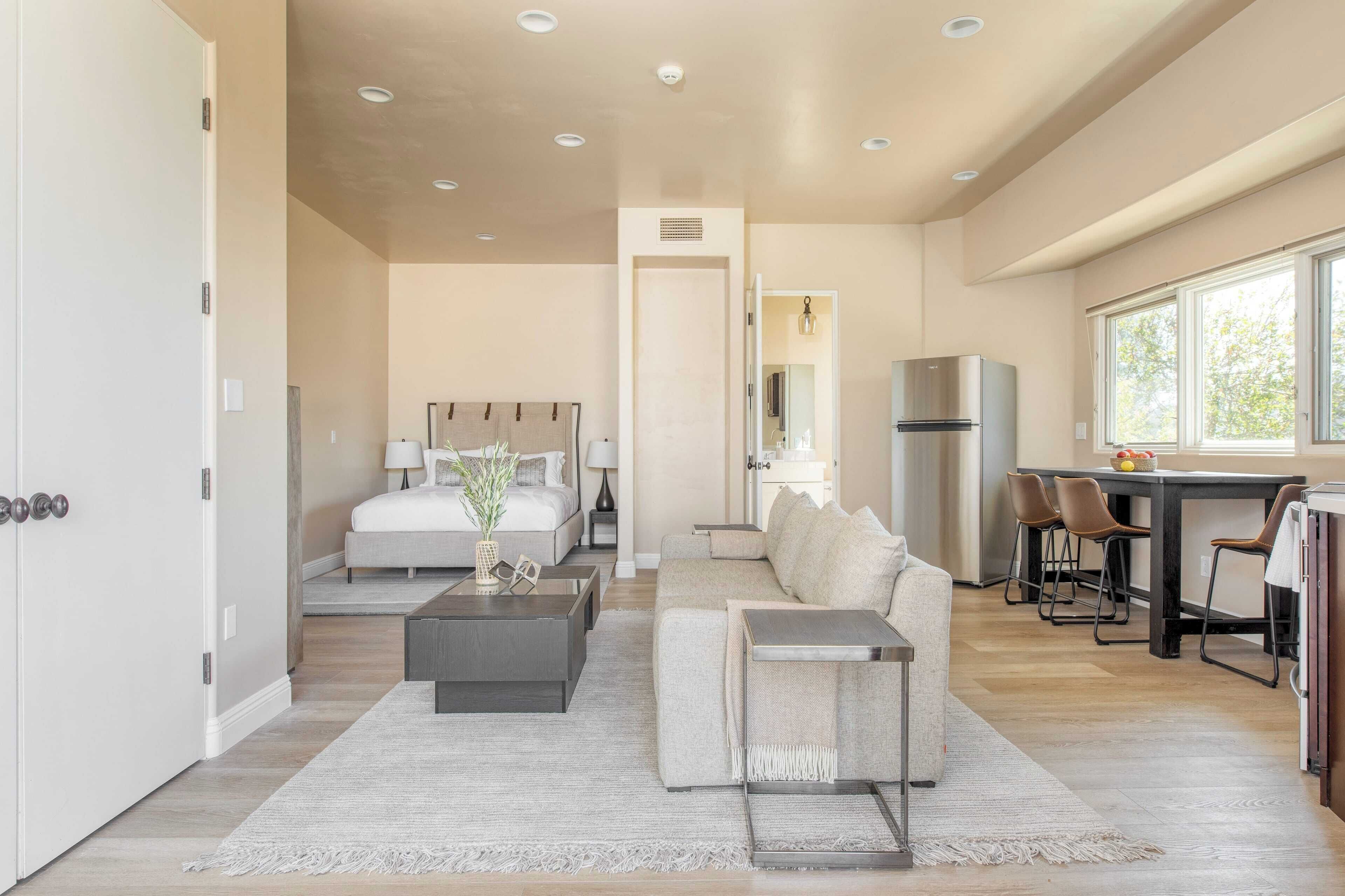 A modern, open-plan living area with a sofa, coffee table, and a dining area with chairs.