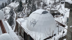 A snow-covered mountain landscape with a dome-shaped building featuring large windows. - GLAMPING CLUB (Manali)