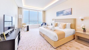 Une chambre d’hôtel avec un grand lit, un bureau avec une télévision, une vue sur la ville et une fenêtre avec des rideaux.