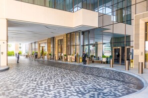 A modern hotel entrance with a check-in desk, a reception area, and a tiled courtyard. - Ultra Luxury Palm Tower with Shared Hotel Facilities (Dubai)