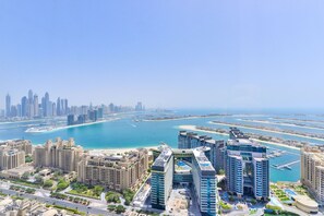 A high-rise hotel with multiple floors, a marina, and a city skyline in the background. - Ultra Luxury Palm Tower with Shared Hotel Facilities (Dubai)