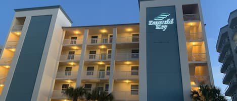 Un hôtel à plusieurs étages, doté de balcons et d’une enseigne bien visible, « Emerald Key ».