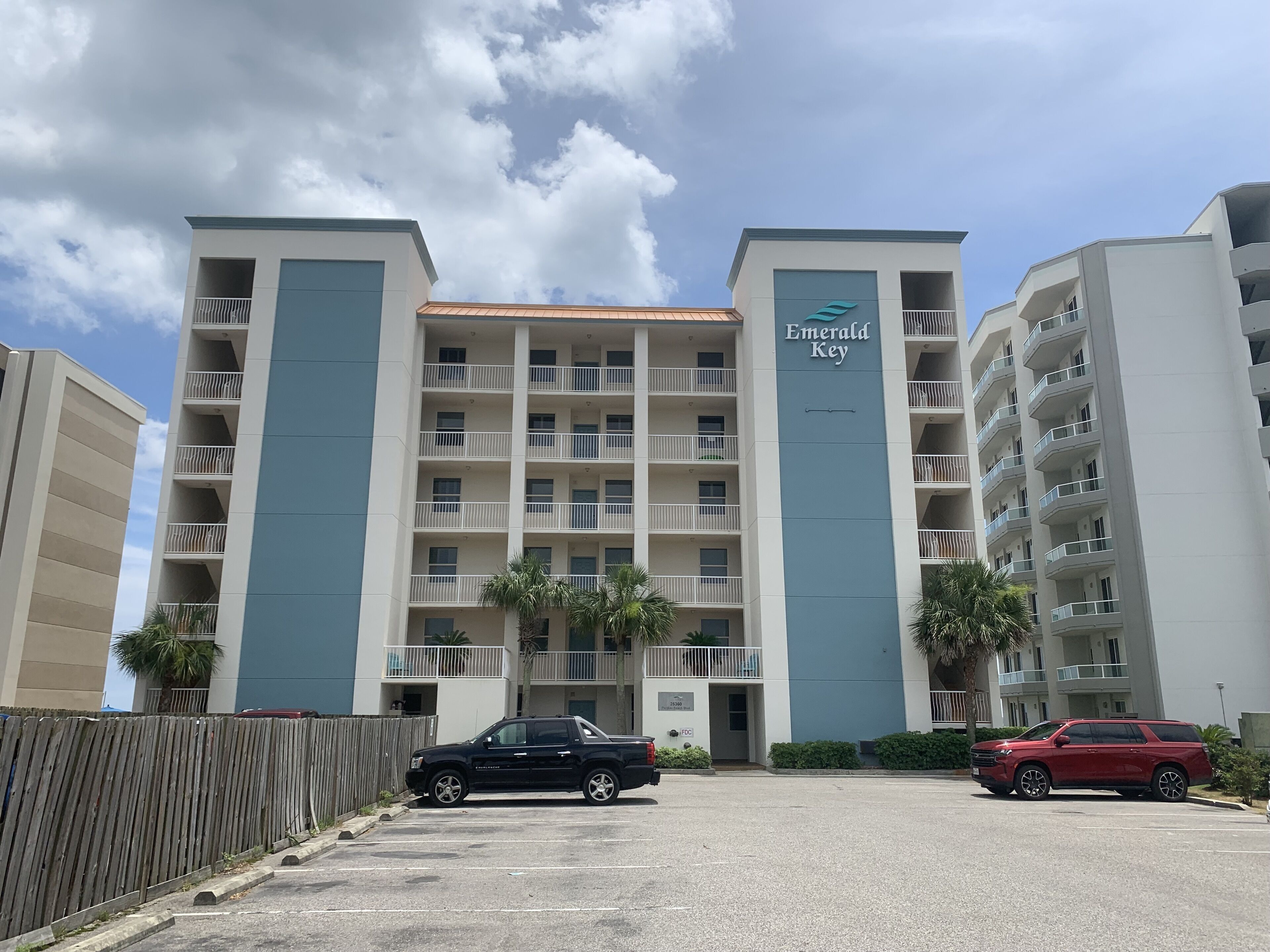 A multi-story hotel with a modern design, featuring balconies and a prominent 'Emerald Key' sign.