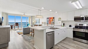 Una cocina moderna con armarios blancos, electrodomésticos de acero inoxidable y una isla grande.