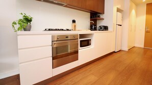 Eine moderne Küche mit weißen Schränken, Edelstahlgeräten und Holzboden.