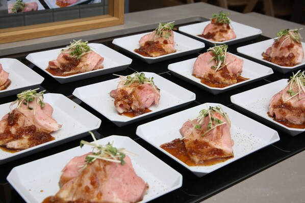 A table with neatly arranged square plates of food, each topped with a piece of meat and garnished with greens. - JR WEST GROUP VIA INN PRIME SAPPORO ODORI (Sapporo)