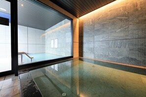 A modern interior with a reflective floor, a wooden bench, and a large window. - JR WEST GROUP VIA INN PRIME SAPPORO ODORI (Sapporo)