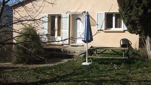 A house with a beige exterior, a front door, and a blue umbrella. - Beautiful independent cottage with garden (Contes)