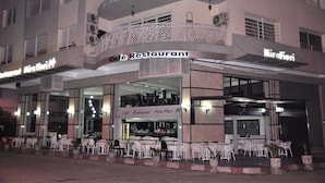 Ein Café-Restaurant mit Außenbestuhlung und einem Balkon.