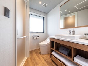 A modern bathroom with a white sink, mirror, and wooden vanity. - Nishitetsu Hotel Croom Hakata Gion (Fukuoka)