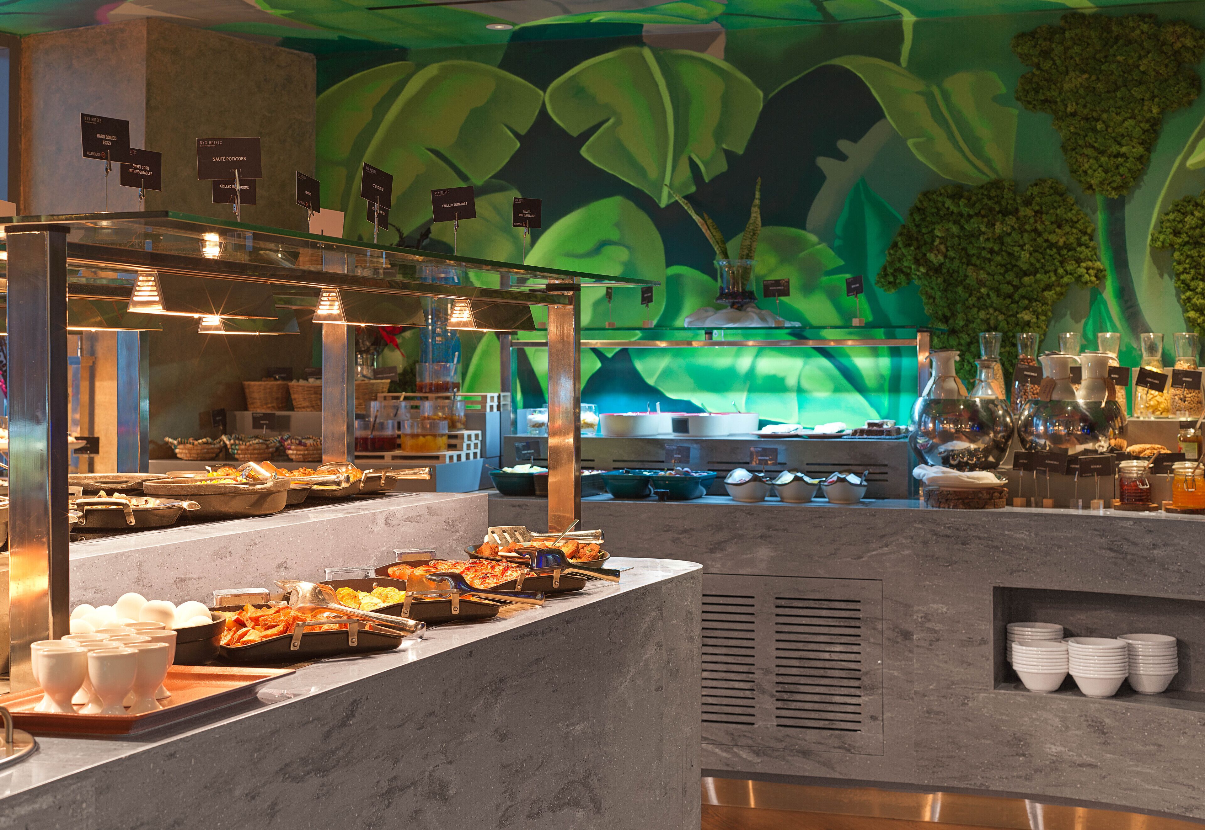 A buffet area with various food items and serving utensils.