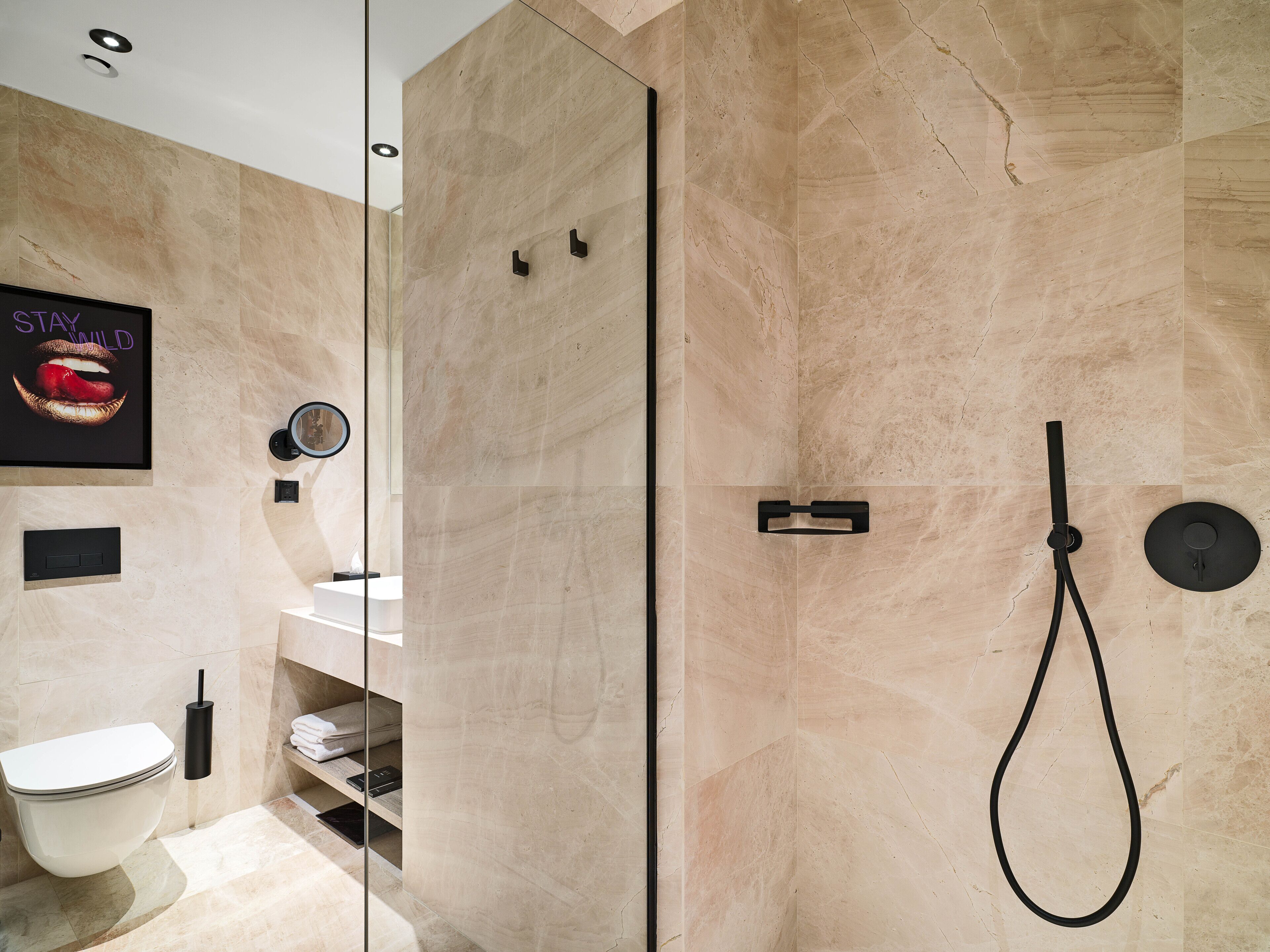 Une salle de bain moderne avec une douche à parois de verre, des toilettes et un lavabo.