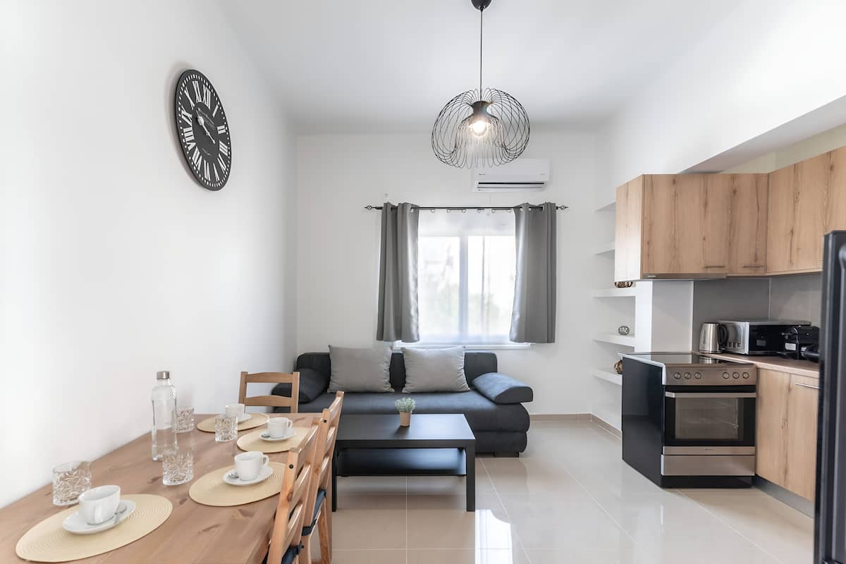 A modern kitchen with a built-in oven and a dining area with a wooden table and chairs.
