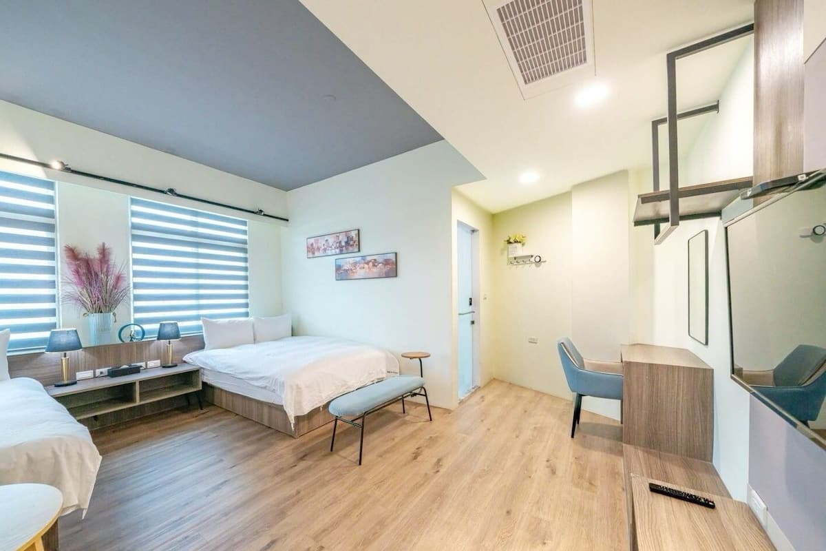Une chambre à coucher moderne avec un lit, une table de chevet et un bureau avec une chaise.