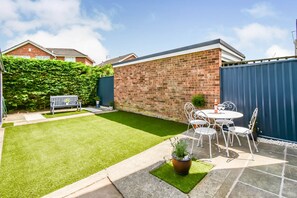Enjoy a serene outdoor space with a patio, lawn, and garden seating area.