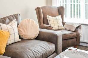 Relax in the living room with a comfortable sofa and coffee table.