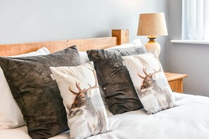 Restful retreat with a comfortable bed, bedside table, and lamp.