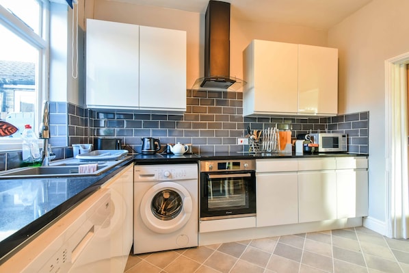 Enjoy cooking in this well-equipped kitchen with appliances, a sink, and ample natural light.