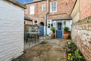 Enjoy al fresco dining and socializing in this charming courtyard with a small table and chairs.