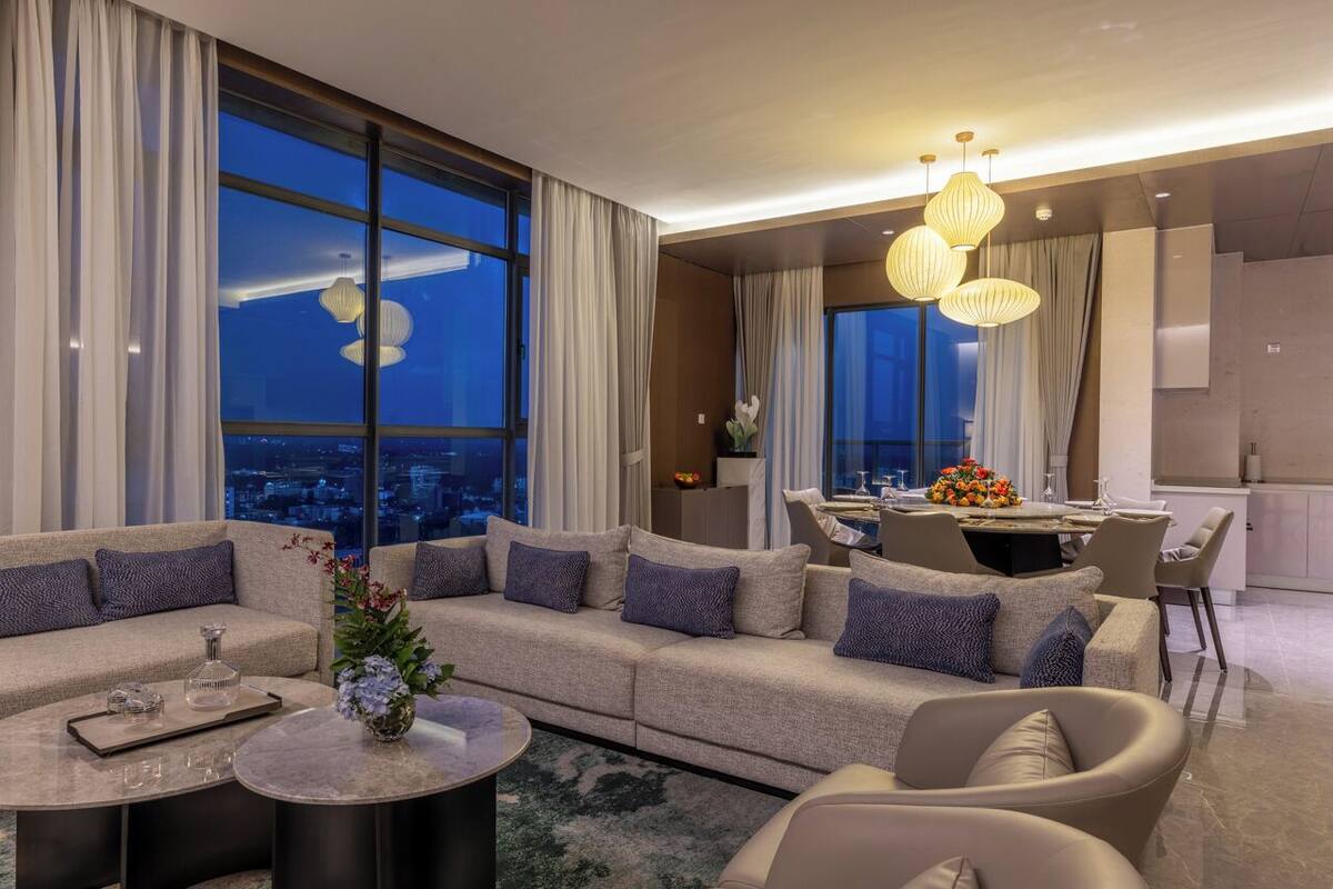 Un salon moderne avec un grand canapé, une table basse et un coin repas comprenant une table et des chaises.