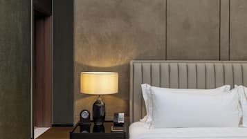 A hotel room with a bed, a nightstand with a lamp, a clock, and a telephone.