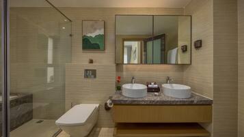 A modern bathroom with two sinks, a large mirror, and a shower area.