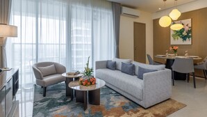 Una sala de estar moderna con sofá, sillón, mesa de centro y comedor.