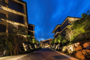 Un edificio moderno con un camino central bordeado de vegetación y rocas.