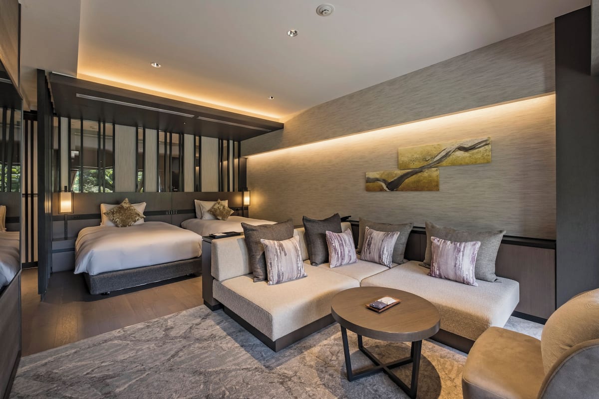 Ett modernt hotellrum med en stor säng, en soffa och ett soffbord.