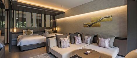 A modern hotel room with a large bed, a sofa, and a coffee table.