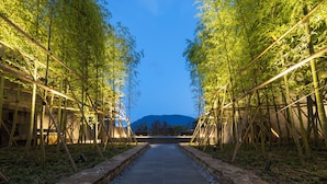 A pathway flanked by bamboo structures with a mountain in the background. - Hakone Gora KARAKU (ORIX HOTELS & RESORTS) (Hakone)