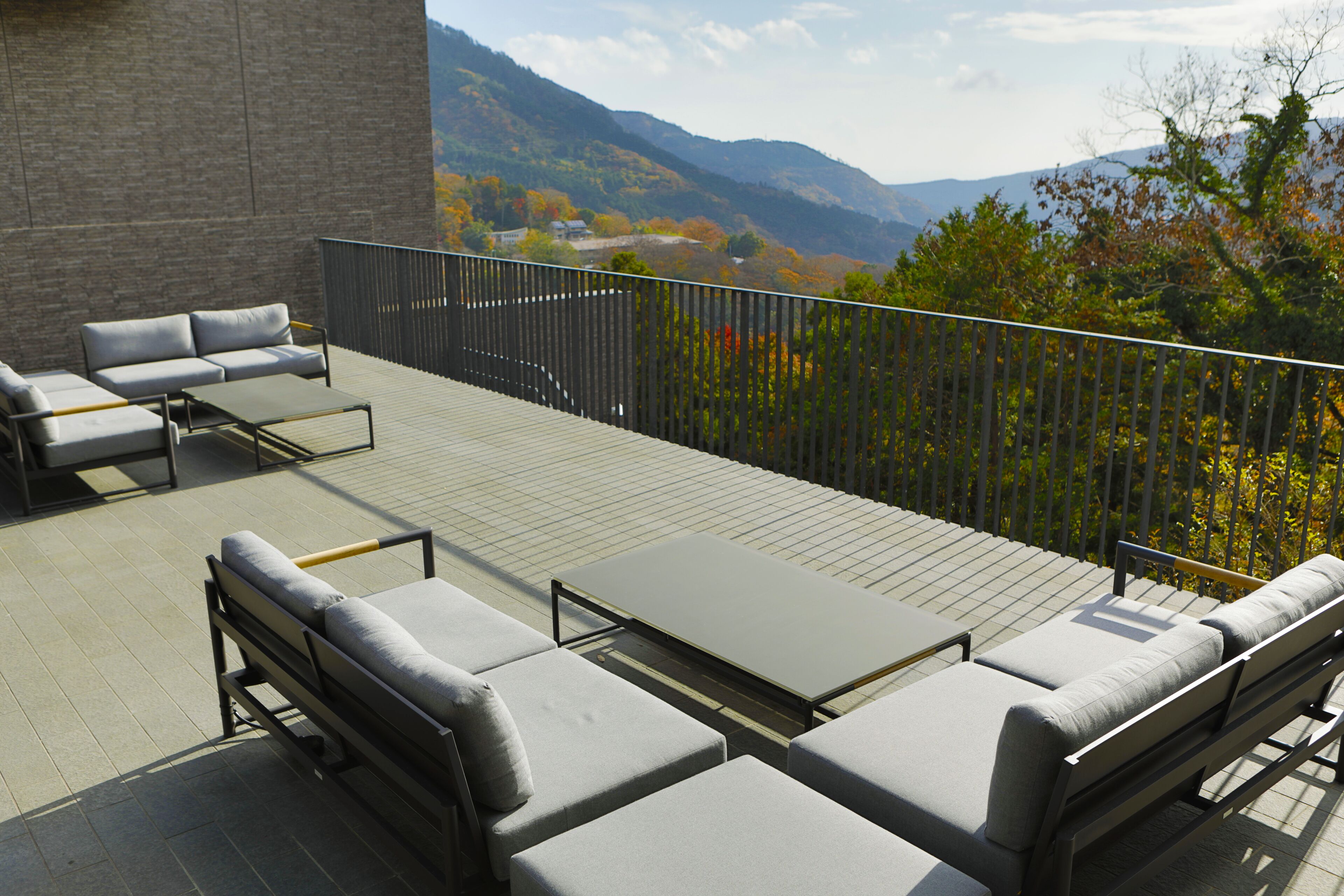 Terraço no telhado com área de estar externa e vista para montanhas.