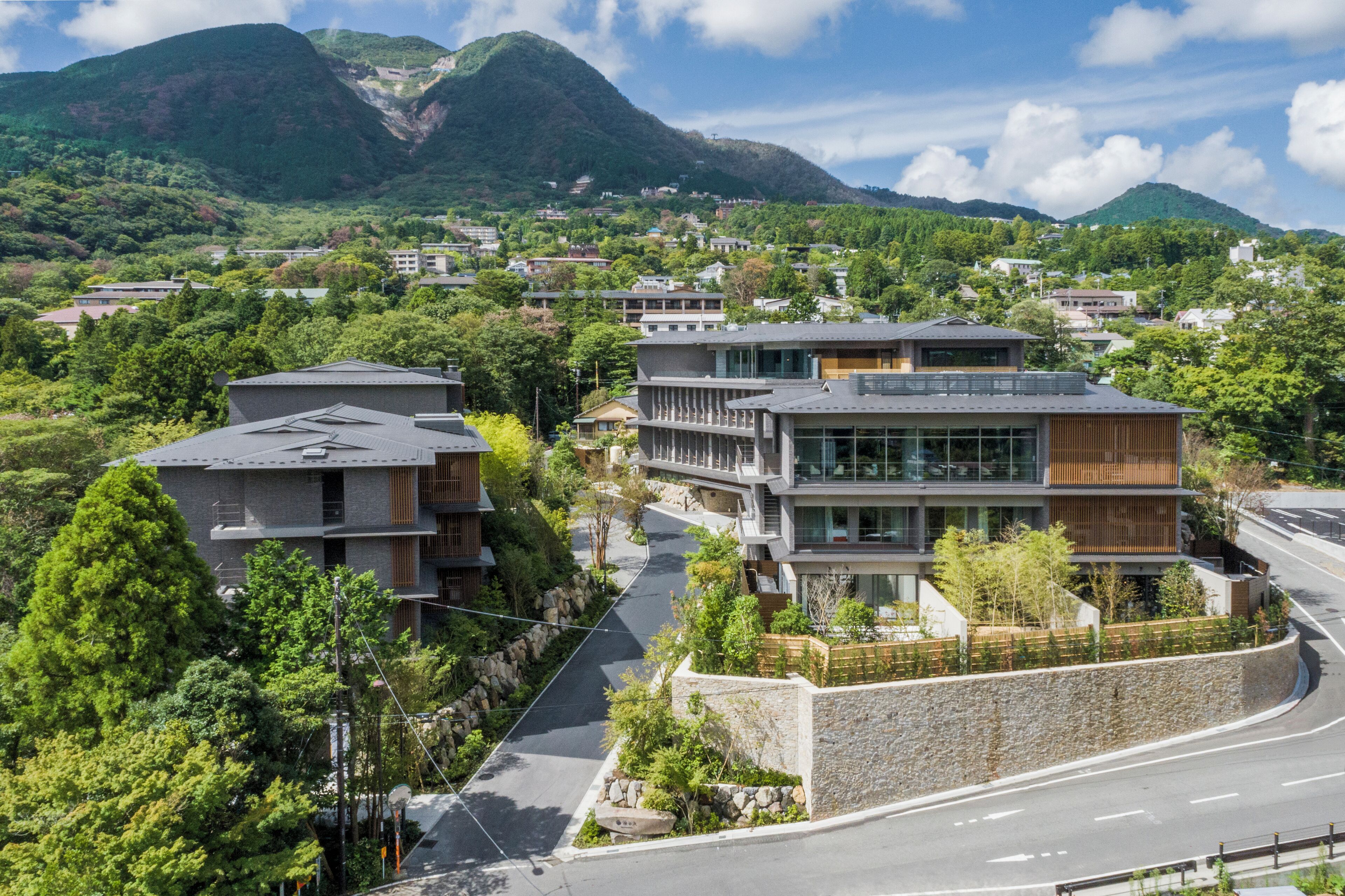 A modern building with a curved driveway and a stone retaining wall.