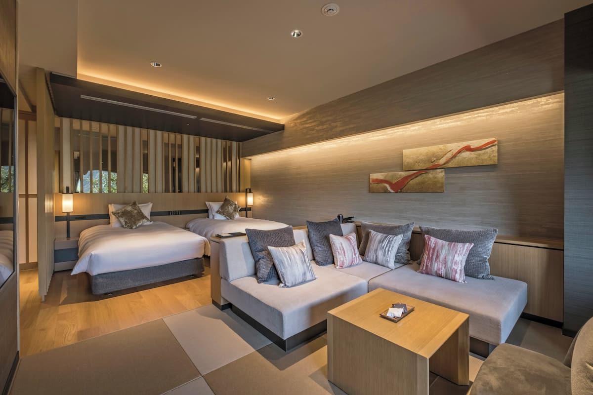 Ett modernt hotellrum med en stor säng, en soffa och ett litet bord.