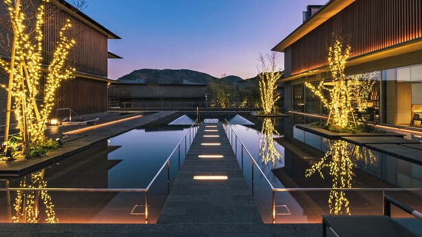 A modern building with a reflective pool and illuminated trees. - Hakone Gora KARAKU (ORIX HOTELS & RESORTS) (Hakone)