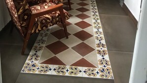 A cozy room with a checkered floor, patterned chairs, a small table, and a lamp. - Villa Kars (Gyumri)