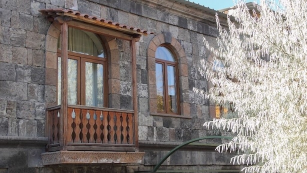 A stone building with a balcony and arched windows. - Villa Kars (Gyumri)