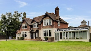 A traditional brick building with a large bay window and a conservatory. - Maple Manor Hotel  (Crawley)
