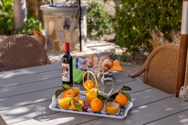 A table with a wine bottle, orange juice, and pastries. - Ca'n Suau Filasop by Rentallorca (Son Macià)