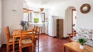 Une cuisine de taille réduite avec un coin repas, une table en bois et un canapé.