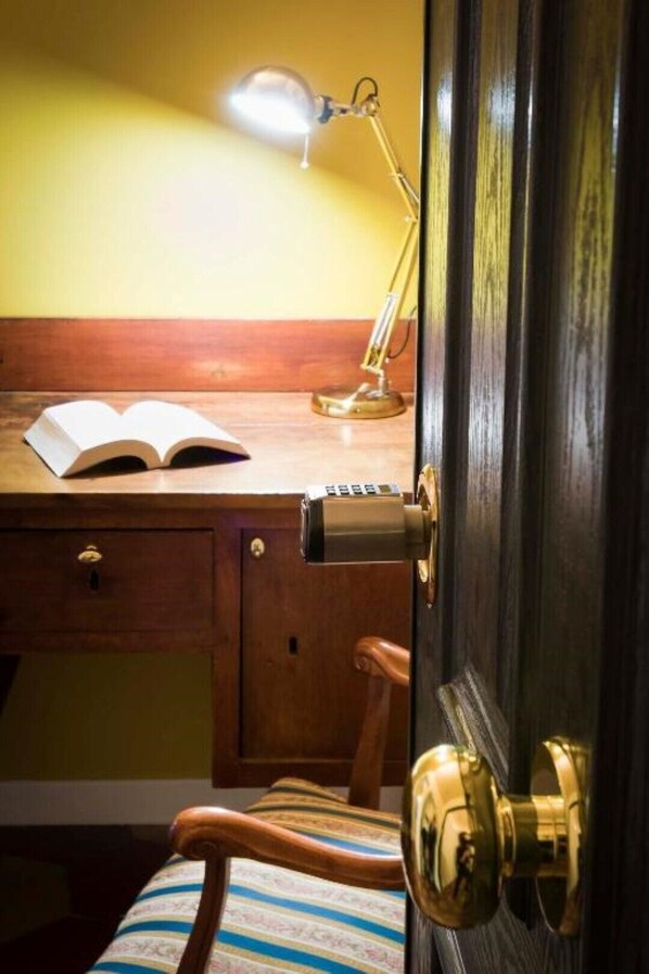 A wooden desk with a lamp, an open book, and a chair. - Luxury Apartment Zona Vaticano-Prati (Roma)