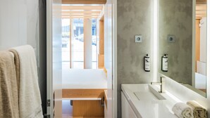 A modern bathroom with a wooden floor, a white sink, and a large mirror. - Sophia Oporto Urban Suites (Porto)