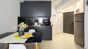 A modern kitchen with dark cabinets, a microwave, and a refrigerator. - Stay Inn on Pushkin Street 43 (Yerevan)