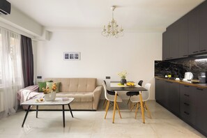 Un salon moderne comprenant un canapé, une table à manger et un coin cuisine.